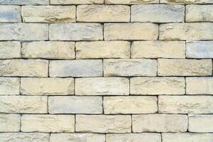 Texture of yellow brick made of sandstone and limestone. The wall of the house. photo