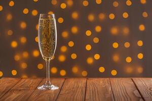 Glasses with champagne on a wooden background against a bokeh background of lights photo