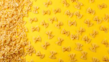 Different types and shapes of dry italian pasta on a yellow background photo