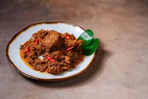 Rendang Pork. Rendang is an Indonesian West Sumatra Minangkabau spicy meat. that slow cooked in coconut milk and mixed spices. photo