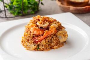 Asian fried rice or nasi goreng with squid, prawns, and fish baso photo