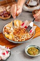 Emie, mie rebus is a noodle soup made from broth shrimp, topping boiled egg and potato, dried shrimp, fried onion and onion leaf. photo