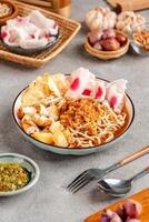 Emie, mie rebus is a noodle soup made from broth shrimp, topping boiled egg and potato, dried shrimp, fried onion and onion leaf. photo