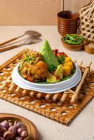 Tumpeng is an Indonesian cone-shaped rice dish with side dishes of vegetables and meat originating from Javanese cuisine of Indonesia. photo
