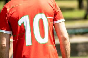 unrecognisable soccer player seen from behind with a red shirt with the number 10 on it photo