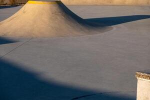 Detail of a public playground for a skateboard in a recreation park on sunset photo