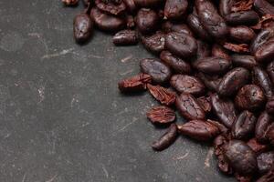 Cocoa beans on black table background photo