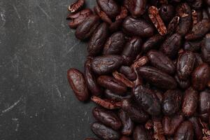 Cocoa beans on black table background photo