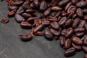 Cocoa beans on black table background photo