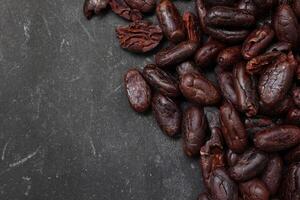 Cocoa beans on black table background photo