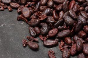 Cocoa beans on black table background photo