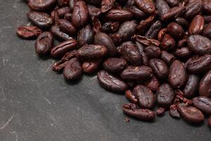 Cocoa beans on black table background photo