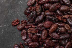 Cocoa beans on black table background photo