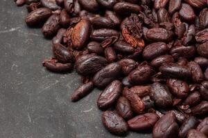 Cocoa beans on black table background photo