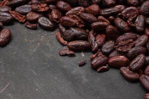Cocoa beans on black table background photo