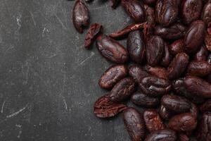 Cocoa beans on black table background photo