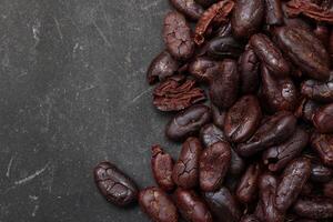 Cocoa beans on black table background photo