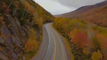 Scenic autumn mountain road winding through colorful foliage, breathtaking landscape view with vibrant fall colors, perfect for travel and nature photography photo