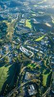 Aerial view of lush suburban landscape with sports fields and residential areas in vibrant morning light photo