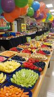Colorful fruit buffet display with balloons and decorations photo