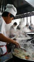 Team of chefs cooking in a professional kitchen with steam rising photo