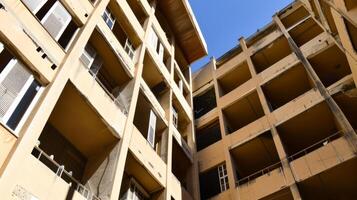 Abandoned and dilapidated apartment buildings with clear blue sky photo