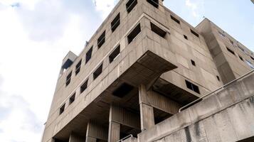 Brutalist architectural structure against the cloudy sky background photo