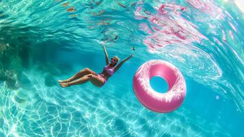 Girl floating on pink inflatable in clear blue pool, enjoying summer photo