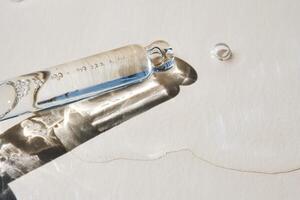 Pipette with serum on a beige background. photo