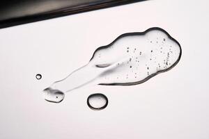 A smear of cosmetic gel close-up on a gray background. Appetizing texture with bubbles. photo