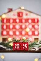 Christmas Advent calendar in the shape of a house with boxes making up the number 2025. photo