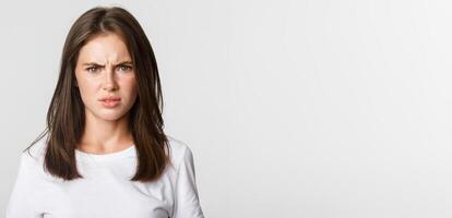 Close-up of skeptical and displeased attractive girl shaking head in rejection, frowning disappointed photo