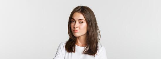 Close-up of attractive brunette girl looking skeptical and unamused photo