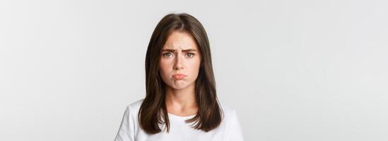 Close-up of sad brunette girl sulking and looking upset photo