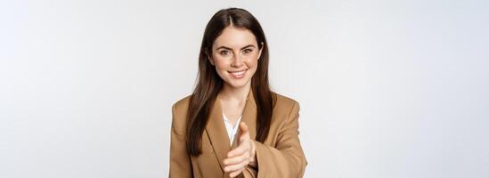 Portrait of smiling businesswoman extend hand for handshake, greeting business partner, saleswoman welcome client, white background photo
