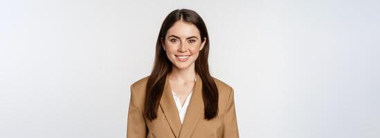 Portrait of business woman with enthusiastic face expression, smiling, looking confident, standing in suit over white background photo