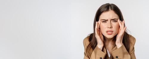 Close up portrait of business woman squinting and looking without glasses, cant see, bad sight without eyewear, standing over white background photo