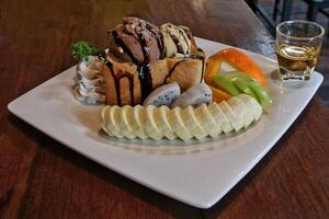 Toast and chocolate ice cream with sliced bananas and oranges photo
