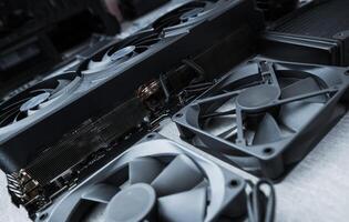 Computer Hardware Components Including Graphic Cards and Cooling Fans on a Workspace photo