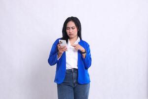 beautiful mature office woman wearing blue formal suit standing pouting candid operating smartphone while touching cellphone screen. for technology content, lifestyle, mobile transactions photo