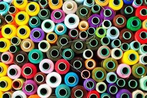 Top view of a vibrant collection of various colored thread spools. photo
