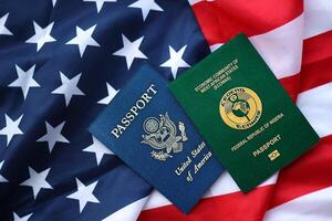 Passport of Nigeria with US Passport on United States of America folded flag photo