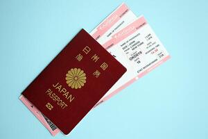 Japan passport with airline tickets on blue background close up photo