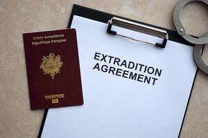 Passport of France and Extradition Agreement with handcuffs on table photo
