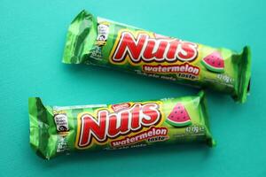 KYIV, UKRAINE - APRIL 20, 2024 Nuts watermelon taste chocolate bar manufactured by Nestle company. Small chocolate with nuts and nougat in colorful wrapping photo