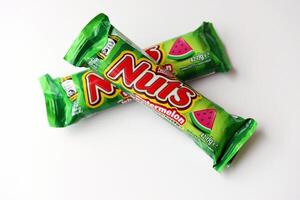 KYIV, UKRAINE - APRIL 20, 2024 Nuts watermelon taste chocolate bar manufactured by Nestle company. Small chocolate with nuts and nougat in colorful wrapping photo