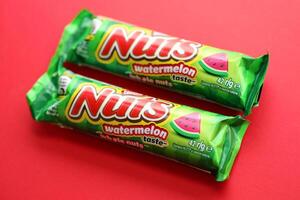KYIV, UKRAINE - APRIL 20, 2024 Nuts watermelon taste chocolate bar manufactured by Nestle company. Small chocolate with nuts and nougat in colorful wrapping photo