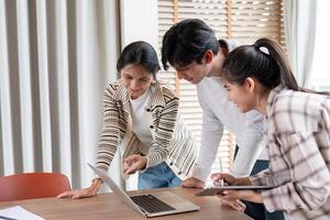 Group of Diverse Student Collaboration on a Project Using a Laptop and Tablet in a Modern Classroom Setting photo