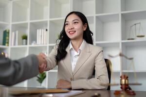 Confident Female Lawyer Shaking Hands with Client in Modern Office Setting, Symbolizing Professional Agreement and Trust photo
