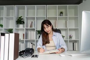Young Student Studying Online at Home Desk with Books and Computer in Modern Minimalist Workspace photo